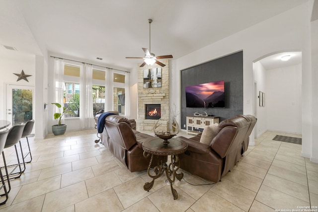 living room with ceiling fan, a fireplace, and light tile patterned flooring