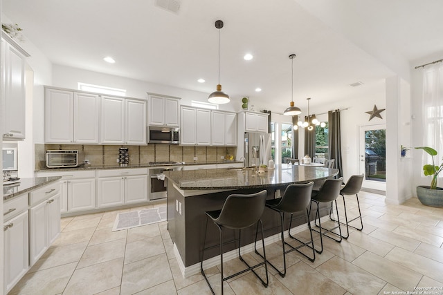 kitchen featuring a center island with sink, white cabinets, and appliances with stainless steel finishes