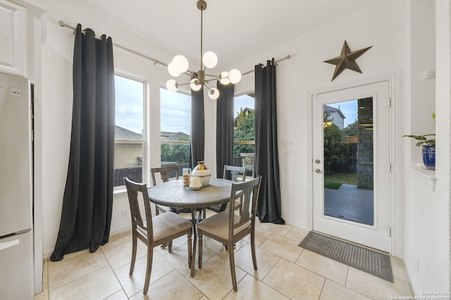 dining area with light tile patterned floors and an inviting chandelier