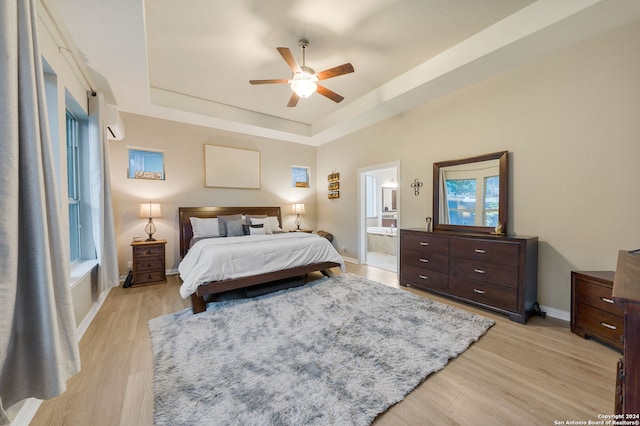 bedroom with multiple windows, light hardwood / wood-style floors, ensuite bath, and ceiling fan