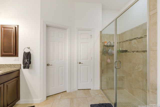 bathroom with tile patterned floors, vanity, and walk in shower