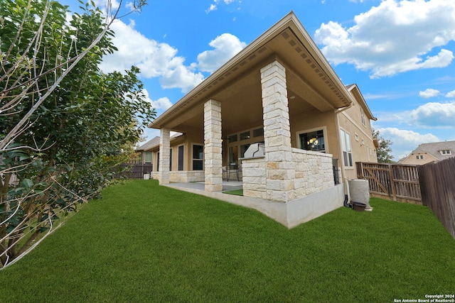 rear view of property featuring a lawn