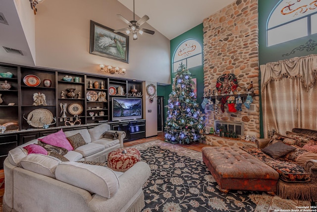 living room with ceiling fan, a fireplace, high vaulted ceiling, and hardwood / wood-style flooring