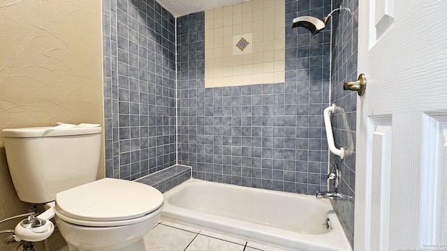 bathroom featuring tile patterned flooring, tiled shower / bath, a textured ceiling, and toilet