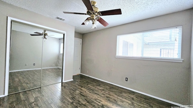 unfurnished bedroom with a textured ceiling, a closet, dark hardwood / wood-style floors, and ceiling fan