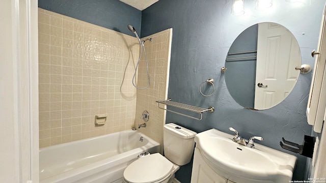 full bathroom featuring tiled shower / bath combo, toilet, and vanity