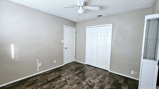 unfurnished bedroom with a textured ceiling, ceiling fan, and dark hardwood / wood-style floors