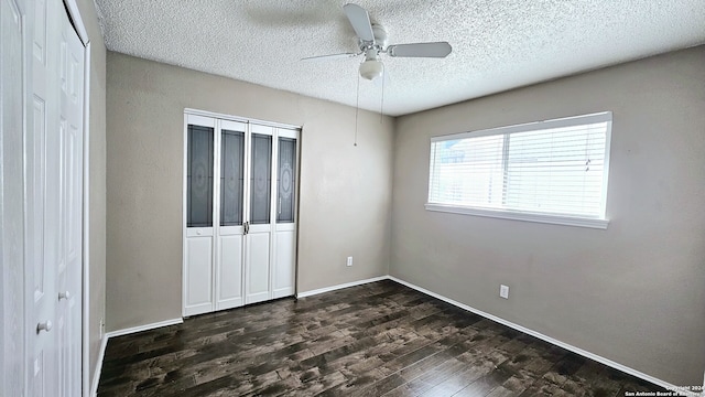 unfurnished bedroom featuring a textured ceiling, dark hardwood / wood-style floors, and ceiling fan