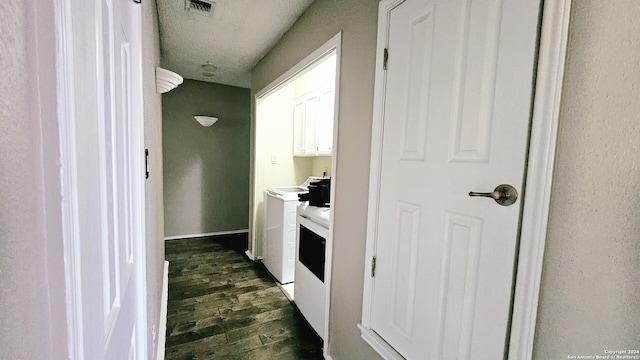 kitchen featuring independent washer and dryer, a textured ceiling, white cabinetry, and dark wood-type flooring