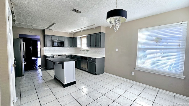 kitchen with plenty of natural light, a kitchen island, sink, and stainless steel appliances