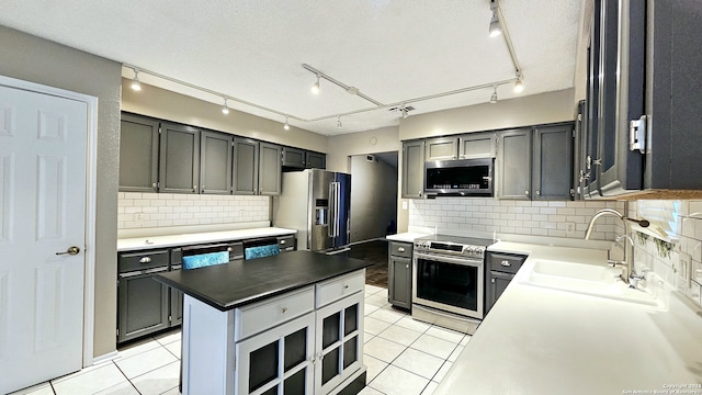 kitchen featuring tasteful backsplash, sink, light tile patterned flooring, and appliances with stainless steel finishes