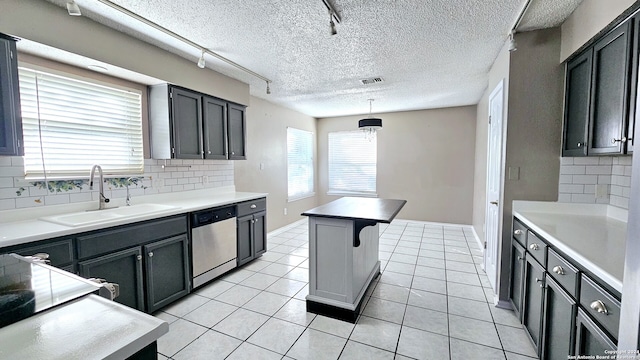 kitchen with a center island, sink, stainless steel dishwasher, decorative backsplash, and decorative light fixtures