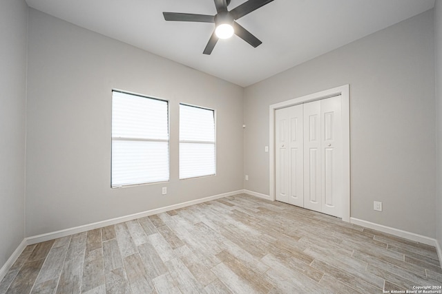 unfurnished bedroom with ceiling fan, a closet, and light hardwood / wood-style floors