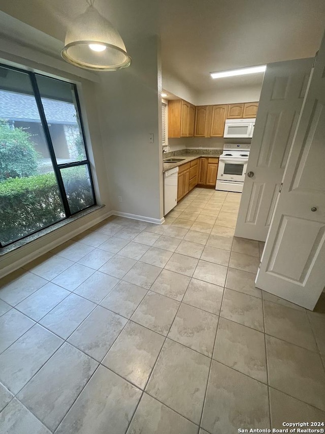 kitchen with light tile patterned flooring, white appliances, and sink