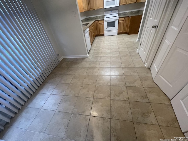 kitchen featuring light tile patterned floors and white appliances