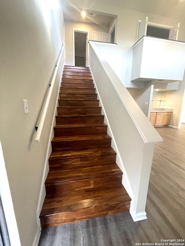 staircase with wood-type flooring