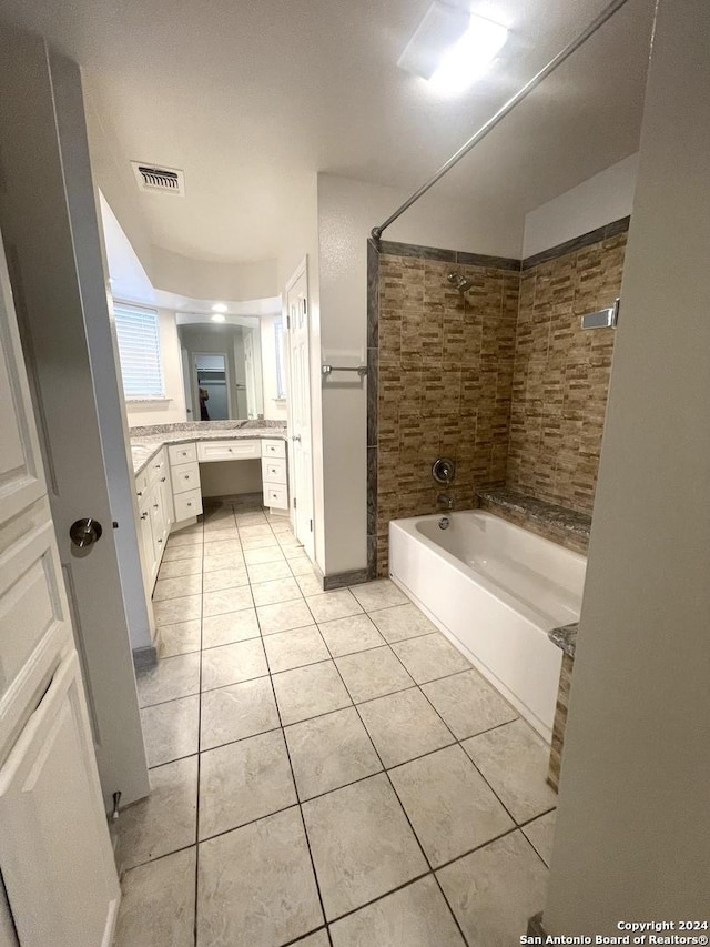 bathroom featuring tile patterned flooring, vanity, and tiled shower / bath