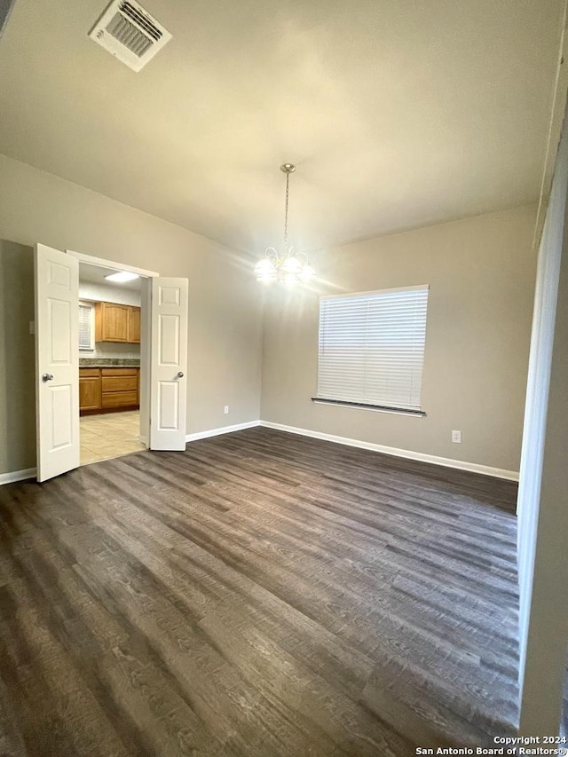 interior space with dark wood-type flooring and an inviting chandelier