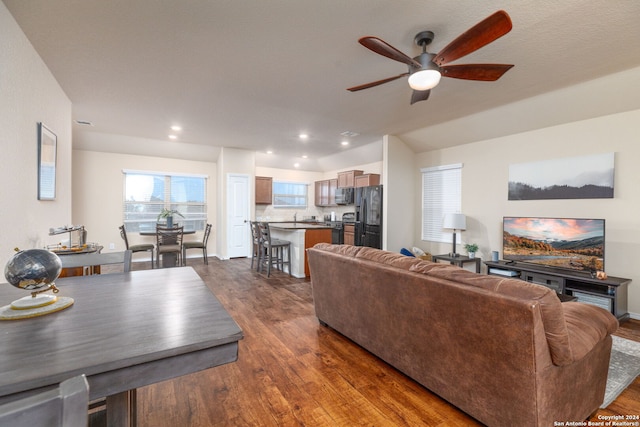 living room with ceiling fan and dark wood-type flooring