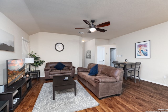 living room featuring a textured ceiling, ceiling fan, dark wood-type flooring, and vaulted ceiling