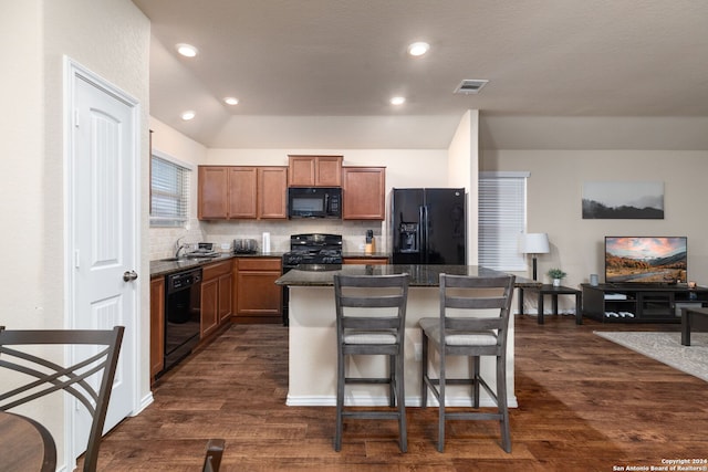 kitchen featuring black appliances, decorative backsplash, a kitchen island, and dark hardwood / wood-style flooring