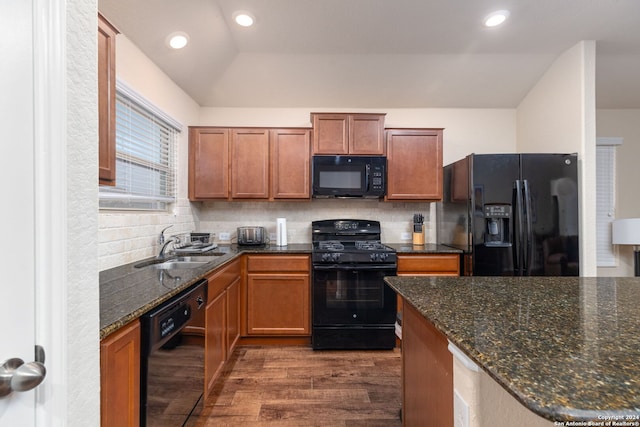 kitchen featuring backsplash, black appliances, sink, vaulted ceiling, and dark hardwood / wood-style flooring