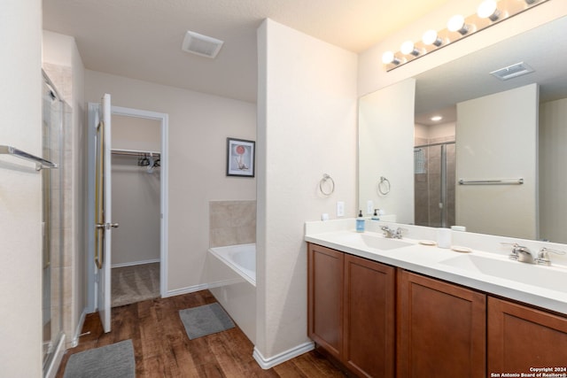 bathroom featuring vanity, independent shower and bath, and hardwood / wood-style flooring