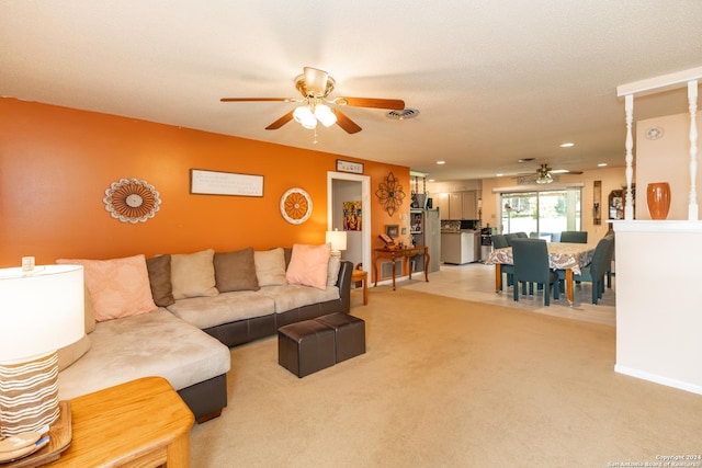 carpeted living room featuring ceiling fan and a textured ceiling