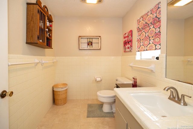 bathroom featuring tile patterned floors, toilet, tile walls, and a textured ceiling