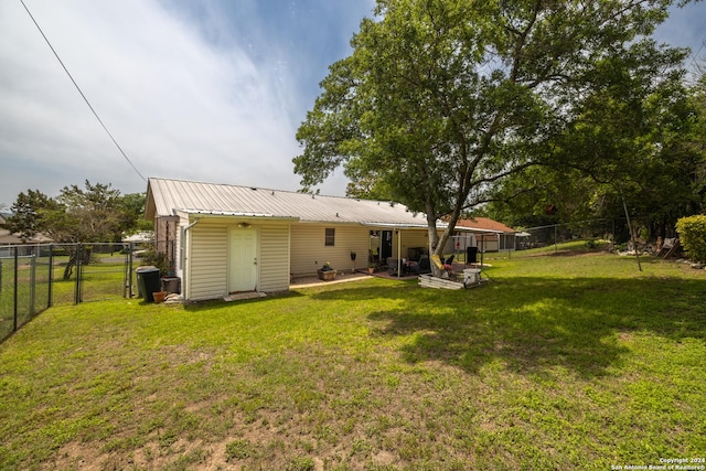 rear view of property featuring a lawn and a patio area