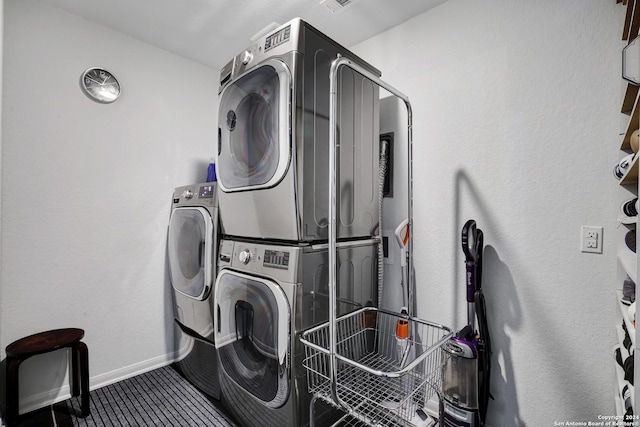 clothes washing area with stacked washing maching and dryer