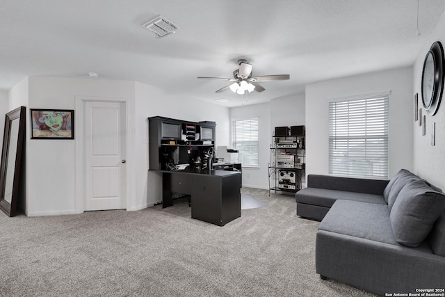 home office featuring light carpet, plenty of natural light, and ceiling fan