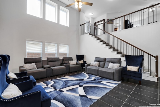 living room with a high ceiling, dark tile patterned floors, and ceiling fan