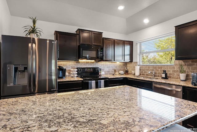 kitchen with black appliances, sink, decorative backsplash, dark brown cabinets, and light stone counters