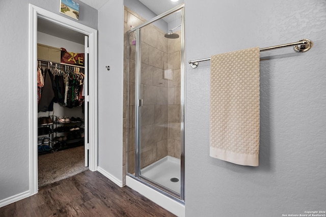 bathroom with walk in shower and hardwood / wood-style flooring