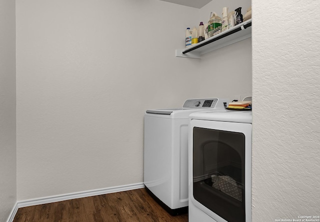 washroom featuring washing machine and clothes dryer and dark wood-type flooring