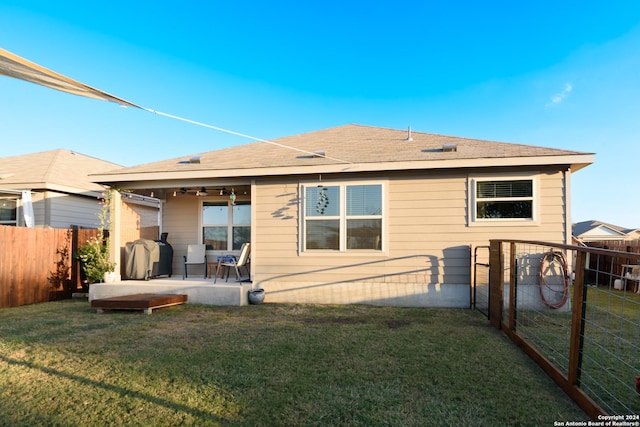 back of property with ceiling fan, a patio area, and a lawn