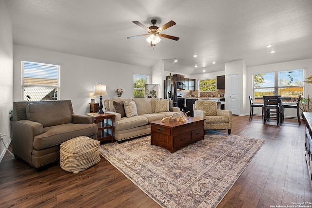 living room with ceiling fan and dark wood-type flooring