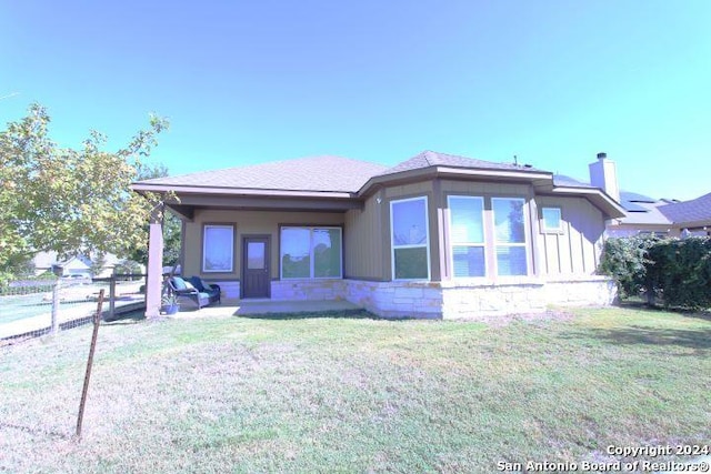 rear view of property featuring a yard and a patio