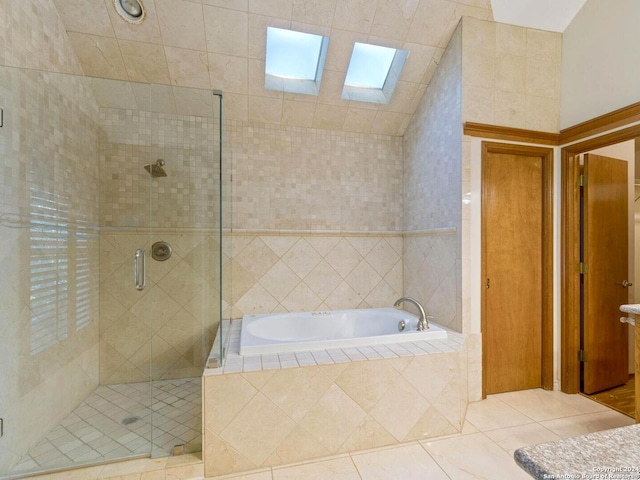 bathroom with tile patterned floors, a skylight, and shower with separate bathtub