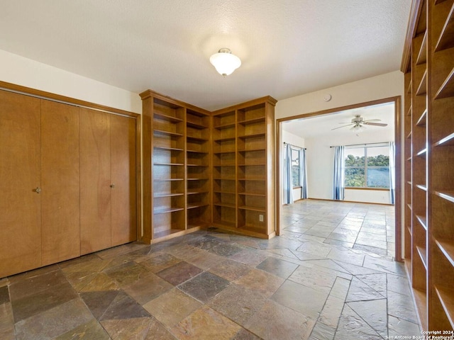 foyer entrance with a textured ceiling and ceiling fan