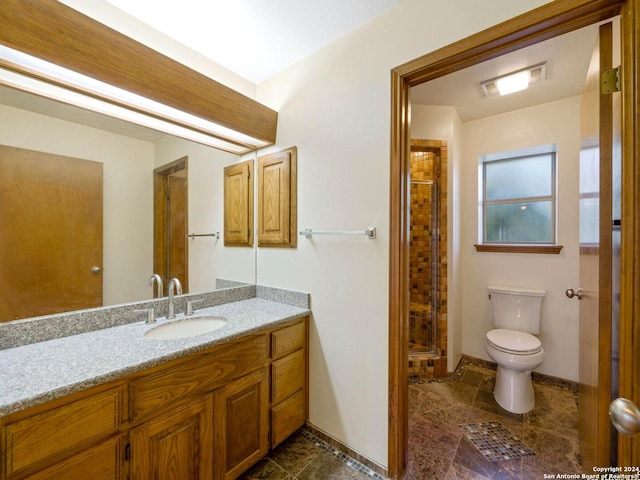 bathroom with vanity, toilet, and a shower