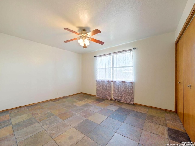 spare room featuring a textured ceiling and ceiling fan