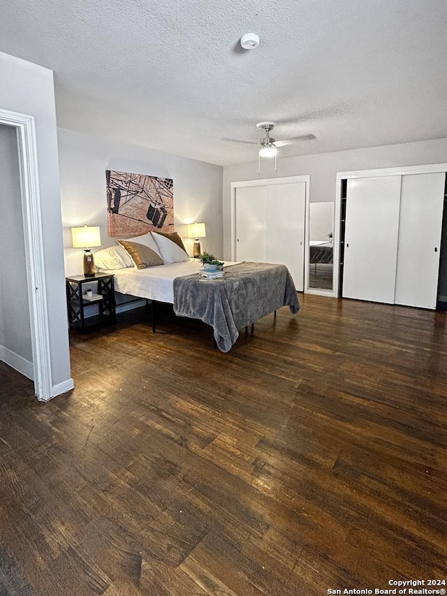 bedroom with ceiling fan, dark hardwood / wood-style flooring, and a textured ceiling