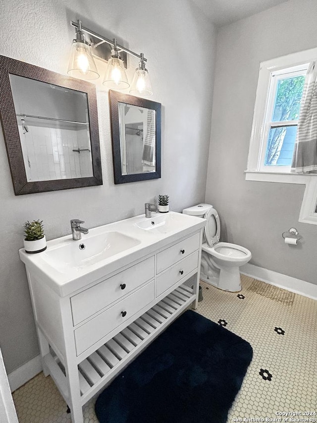 bathroom with walk in shower, tile patterned flooring, vanity, and toilet