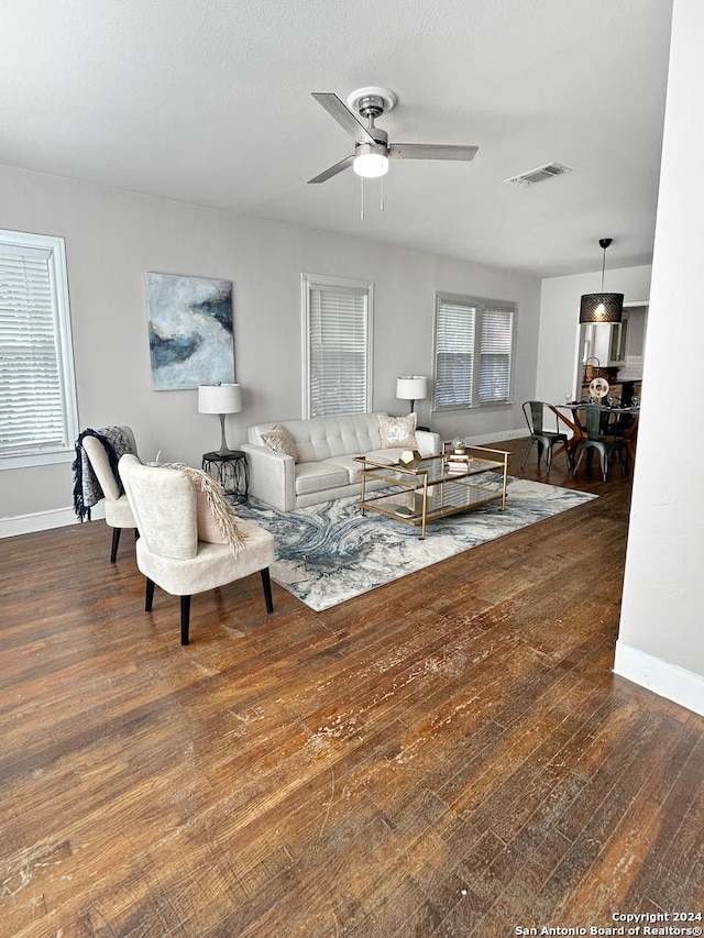 living room featuring ceiling fan and dark hardwood / wood-style flooring