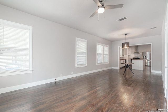 living room featuring a wealth of natural light, ceiling fan, and dark wood-type flooring