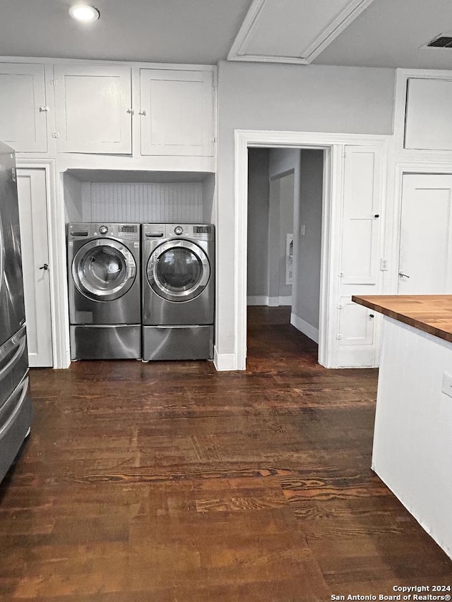 laundry area featuring dark hardwood / wood-style floors, cabinets, and washing machine and clothes dryer