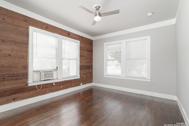 spare room featuring dark hardwood / wood-style floors, wood walls, ceiling fan, and cooling unit