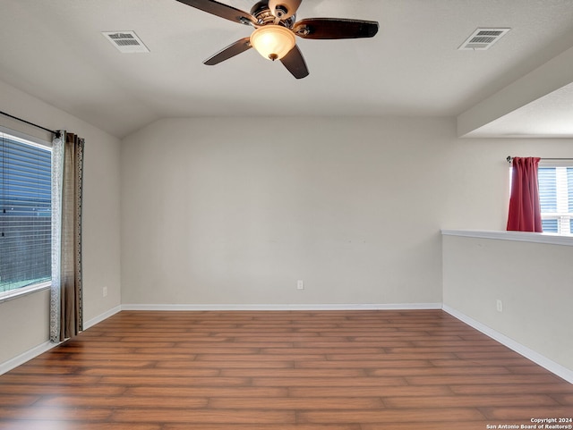 empty room featuring vaulted ceiling, ceiling fan, and dark hardwood / wood-style floors